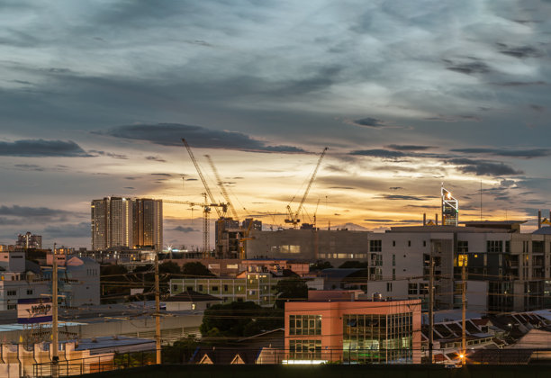 曼谷城市夜景，正在建设的高楼大厦与起重机，背景是戏剧性的天空。图片下载