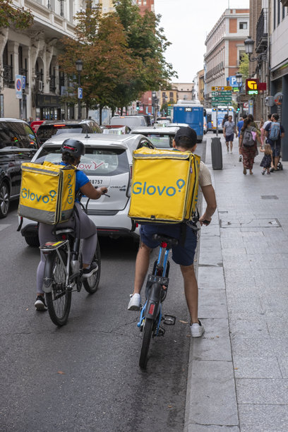 马德里，马德里。2024年8月29日 - 一男一女作为Globo的食品配送员骑自行车工作。图片下载