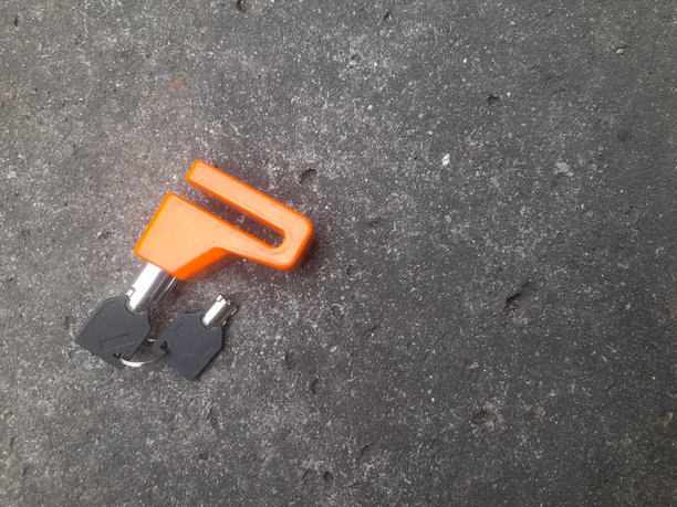 从上方看摩托车安全锁，背景为道路纹理。图片下载