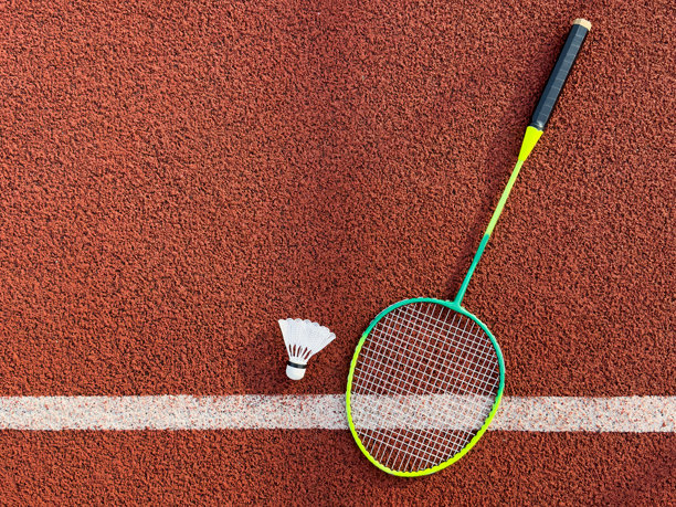 奶油白色的羽毛球和球拍在羽毛球场上，留白，柔和且选择性对焦。图片下载