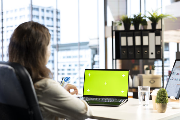 在自己的办公室里工作的女商务主管，背景为绿幕。图片下载