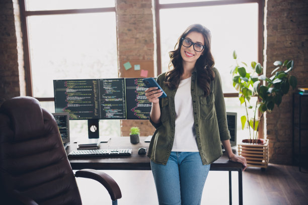 成功的可爱聪明女性网页设计师在早晨的阁楼办公室中心工作站使用设备进行研究的照片图片下载