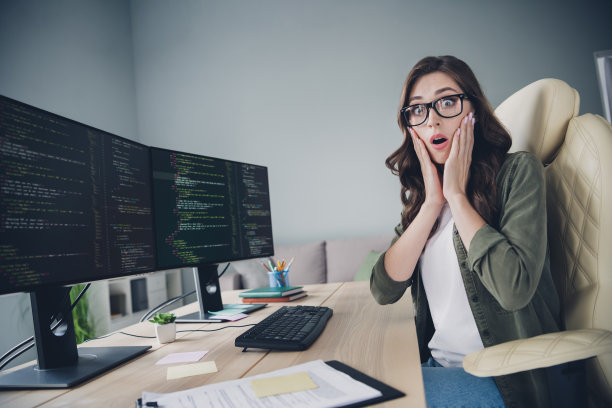 担忧和压力的女士侧面照片，惊讶地用手捂住脸颊，显示出错误、麻烦和失败的情绪，室内工作站环境。图片下载