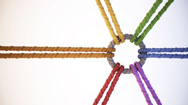 五彩缤纷的绳索连接成一个圆形的结，象征着创意工作环境中的团队合作与协作图片下载