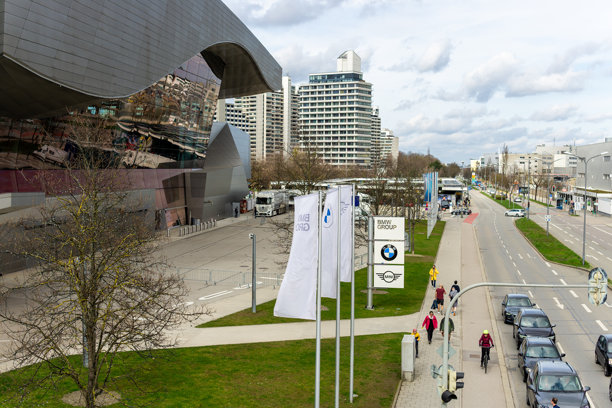 德国慕尼黑。宝马WELT博物馆旁的道路。人们在开车、骑车和步行。宝马世界体验是一个建筑地标，也是一个观光胜地，可以欣赏到汽车和摩托车。图片下载
