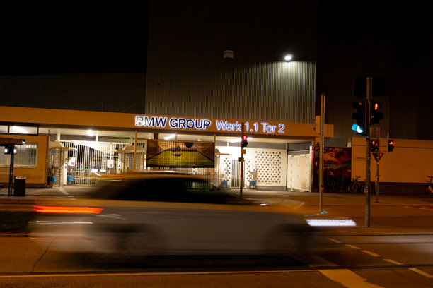 宝马集团工厂办公楼的外立面在夜间被照亮。快速车辆的光束经过，长时间曝光。Werk 1.1 Tor 2. Gate 2. 高质量照片图片下载