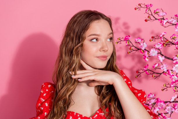 美丽少女的照片肖像，迷人梦幻的樱花盛开，穿着时尚的红色服装，背景为粉色。图片下载