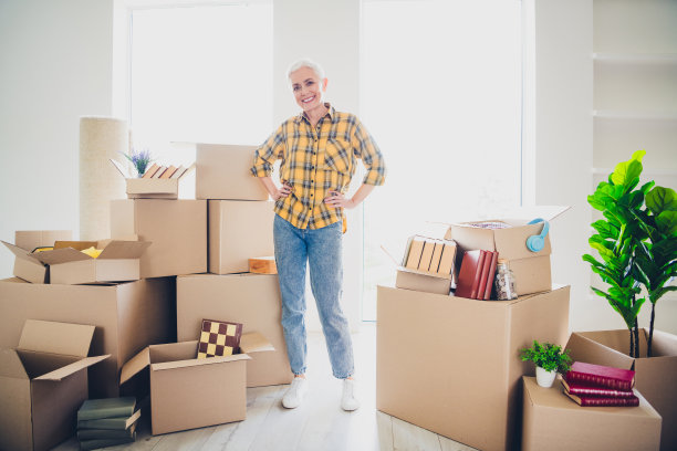 穿着格子衬衫的优雅老年女性在新公寓室内摆姿势的全身照片图片下载