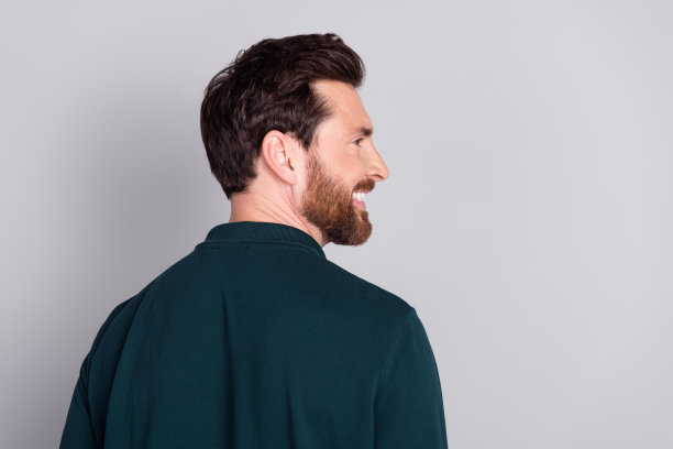 穿着时尚绿色衣服的帅气迷人男士的个人头像，背景为灰色。图片下载