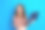 可爱的年轻女士的照片肖像，穿着时尚的彩色服装，坐在旧笔记本电脑前，背景为蓝色，显得空旷。图片下载