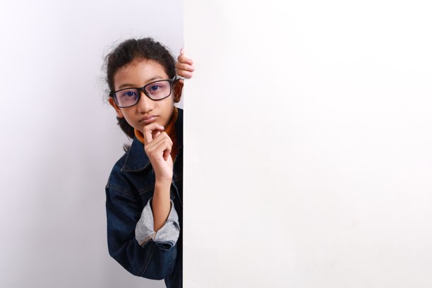 好奇的亚洲小女孩在白墙后面偷看，十分搞笑。图片下载