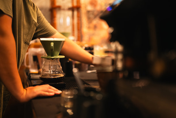 复古咖啡师在迷人的咖啡馆中制作完美的浓缩咖啡，热饮如卡布奇诺和拿铁盛在杯中，专业的精准香气充盈早晨，棕色饮品在温馨的环境中温暖顾客。图片下载