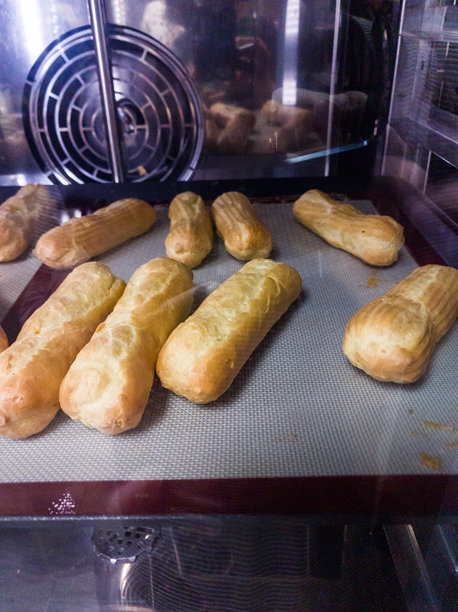 法式糕点食品：在风扇烤箱中烹制的闪电泡芙甜点、奶油酥皮、烹饪食品、蛋糕食谱、鲜奶油、牛奶、花、鸡蛋、香草、糖，选择性聚焦，浅景深，开罗图片下载