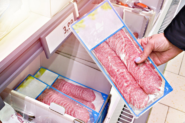 手中拿着切片香肠的商店场景图片下载