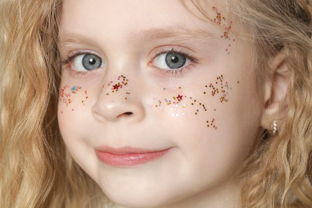 可爱的小金发女孩，蓝色眼睛，脸上有闪光粉。图片下载