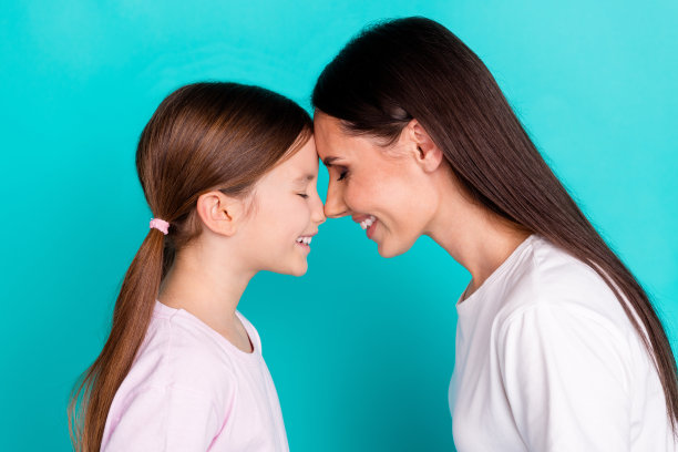 漂亮可爱的女孩与妈妈在青色背景下共度时光的照片图片下载