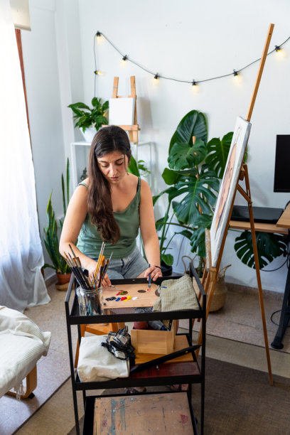 女性插画师在她的艺术工作室调配颜料进行绘画图片下载