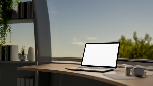 现代房间桌子上的笔记本电脑模型，靠在大窗户旁，窗外可以看到天空。图片下载