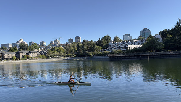 温哥华BC省加拿大格兰维尔岛上的人们在夏天划皮划艇，背景是住宅房屋。图片下载