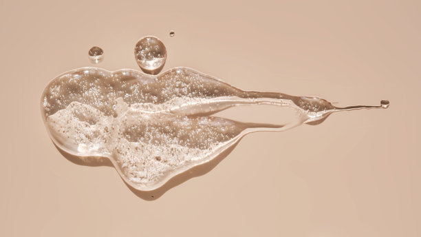 一滴润滑剂或化妆凝胶在米色背景上。图片下载