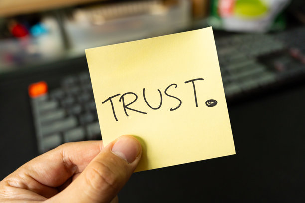在黄色便签上手写“信任”字样。金融和商业概念。市场营销。品牌建设。图片下载