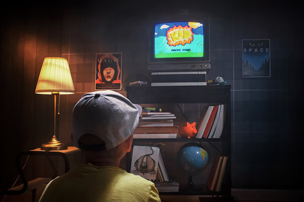 男孩在他的房间里玩电子游戏图片下载