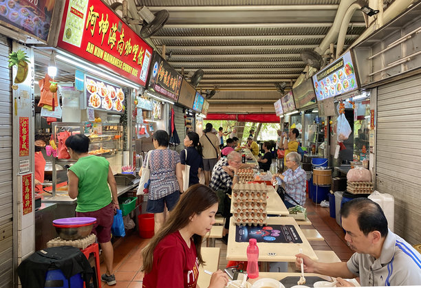 顾客在武吉知马市场与美食中心的摊位前用餐。小贩中心计划拆除，一些摊位将搬到附近的临时地点。图片下载