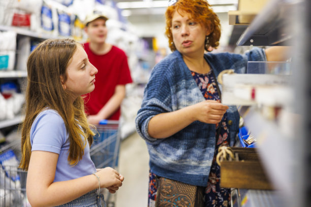母亲引导年轻女儿进行购物体验。图片下载