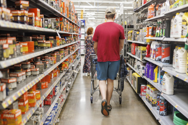 自闭症患者的购物经历。年轻男子在超市过道专注于购物，身旁陪伴着一位女孩。图片下载