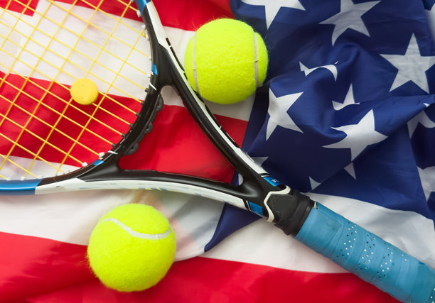 一把网球拍和一个网球放在美国国旗上。网球比赛概念图片下载