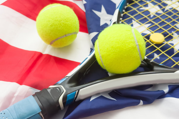 一把网球拍和一个网球放在美国国旗上。网球比赛概念图片下载