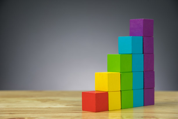 五颜六色的堆叠玩具积木放在灰色背景的桌子上图片下载