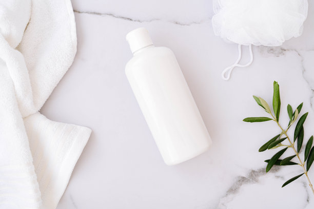 白色大理石背景上的平铺白色无标签塑料瓶、身体海绵、毛巾和橄榄枝图片下载