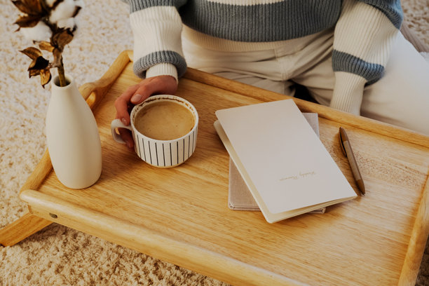 舒适的早晨布置，咖啡、笔记本和装在花瓶里的棉花枝放在木托盘上。非常适合生活方式、家居装饰和极简主义主题。图片下载