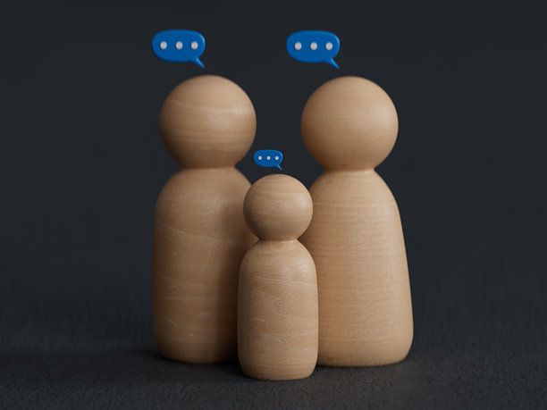 家庭成员在桌子上与木制模型聊天。人们的生活方式和关系关心与理解的概念。爱的对话和沟通主题。图片下载