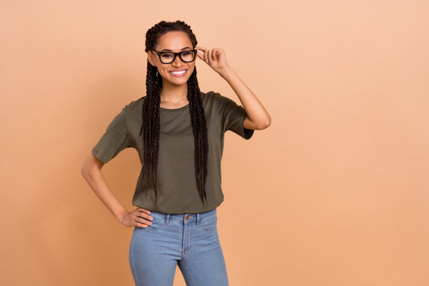 一位快乐的漂亮人物手放在腰间，戴着眼镜，露出灿烂的微笑，背景为米色。图片下载