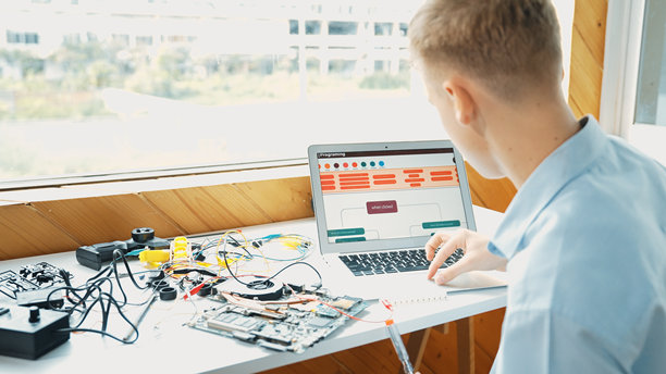 学生在看着笔记本电脑屏幕编写工程提示。启发。图片下载