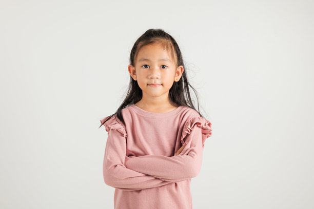 亚洲可爱的小女孩自信地微笑，双臂交叉，工作室拍摄，白色背景，留有空白空间。图片下载