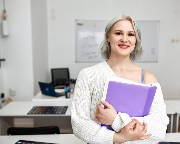 一位漂亮年轻女性在学校工作的照片。在线外语教师图片下载
