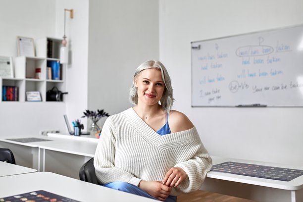 一位漂亮年轻女性在学校工作的照片。在线外语教师图片下载