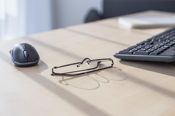 办公桌上放着黑框眼镜、键盘和鼠标图片下载
