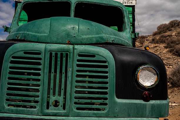 一辆带有黑色前大灯的绿黑色卡车图片下载