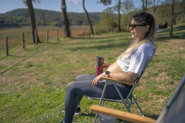 一位孕妇坐在草地上的椅子上图片下载