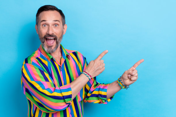 老年成熟男性的肖像照片，灰色胡须，张嘴，手指指向空旷的地方，惊讶而疯狂，打破新闻，背景为蓝色。图片下载