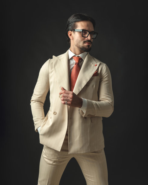 放松的商人穿着米色西装，特写镜头中打响指。图片下载