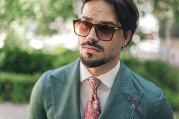 时尚商人戴着太阳镜，侧目凝视的特写视频图片下载