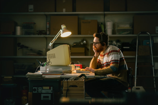 聪明的书呆子在夜晚使用一台旧电脑工作图片下载