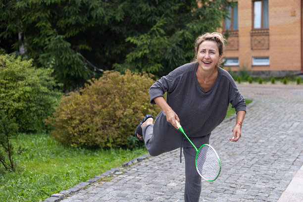 微笑的中年妇女打羽毛球图片下载