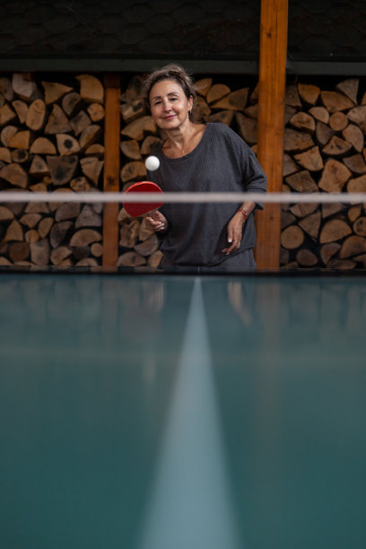 微笑的中年女性在打乒乓球图片下载