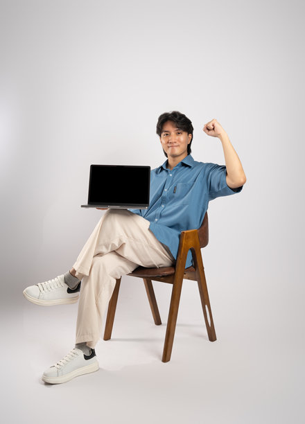 年轻亚洲商务男士坐在椅子上，背景为白色。图片下载